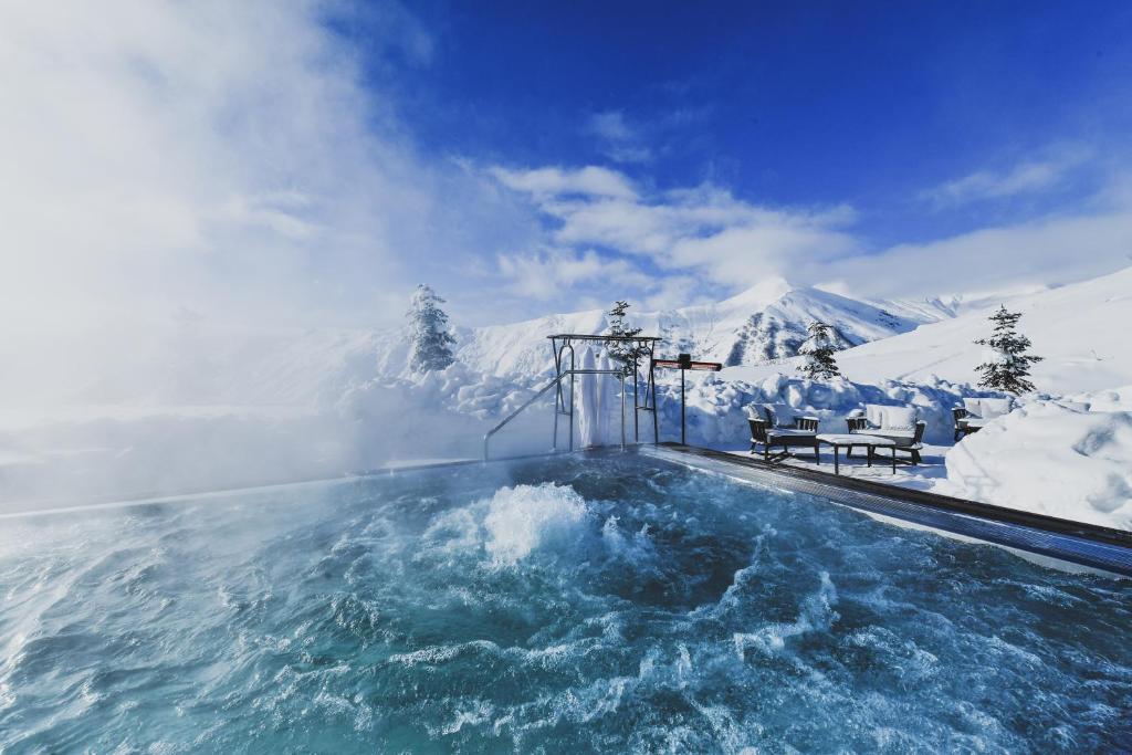 Heated outdoor pool steaming in deep snow under a clear blue sky