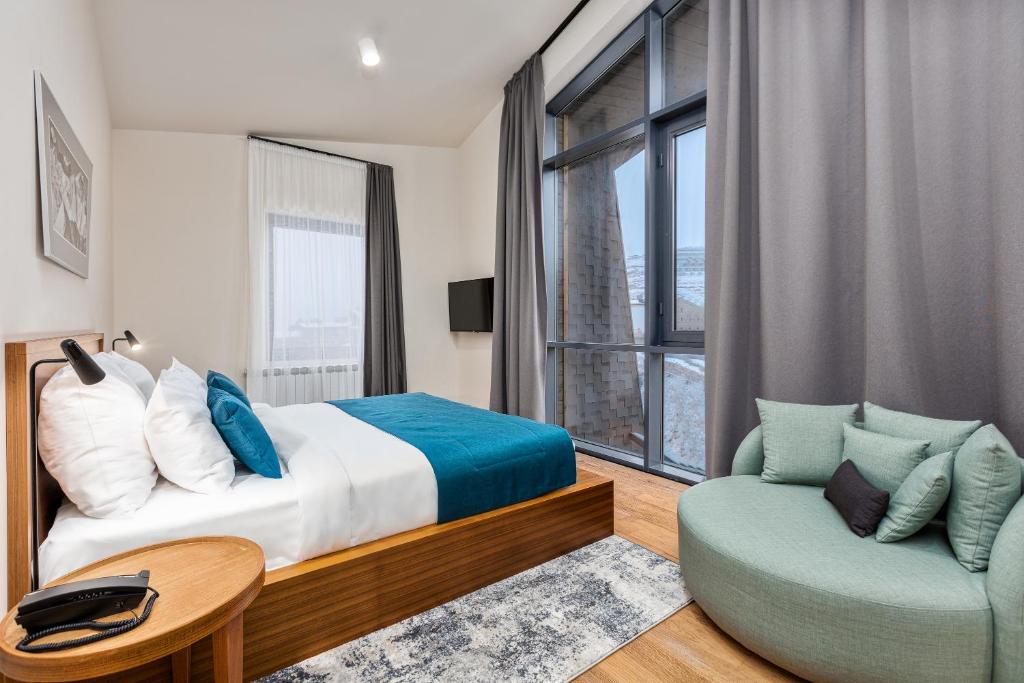 Contemporary bedroom with a low timber bed, circular armchair and large windows