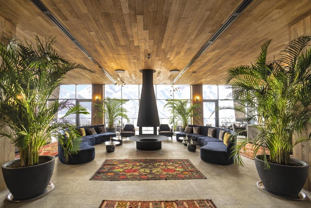 Lounge with a suspended fireplace and panoramic windows onto snowy mountains