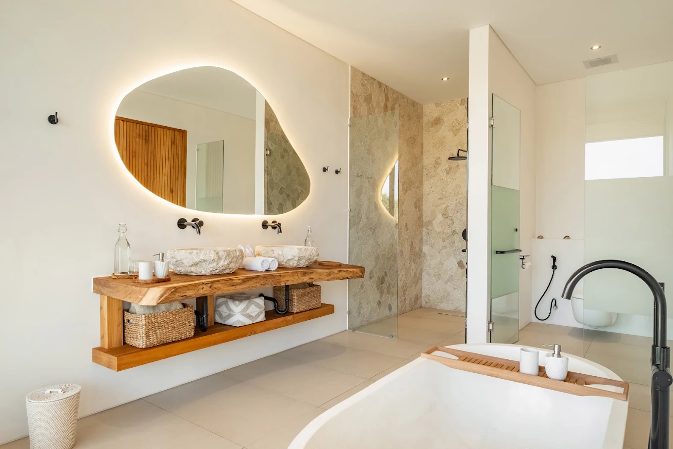 Bathroom with a freestanding soaking tub, timber vanity and backlit mirror