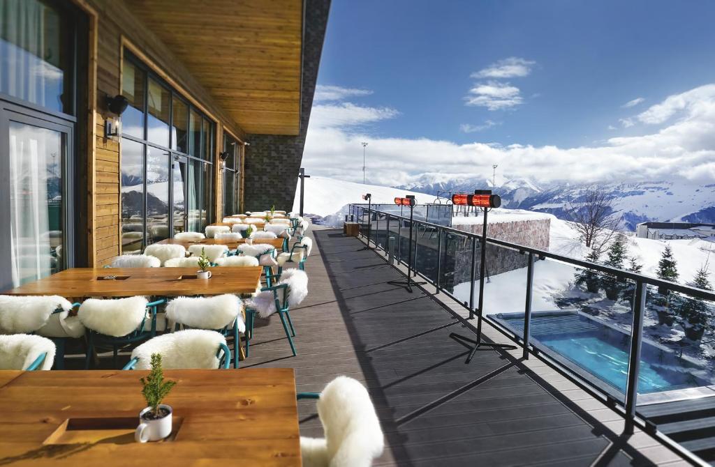 Outdoor dining terrace set for lunch with a snow-covered mountain view